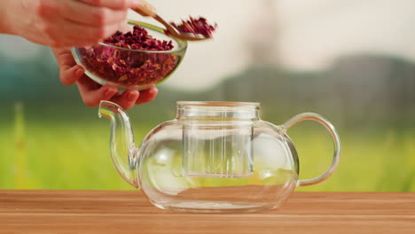 preparing rose petal tea in a glass teapot