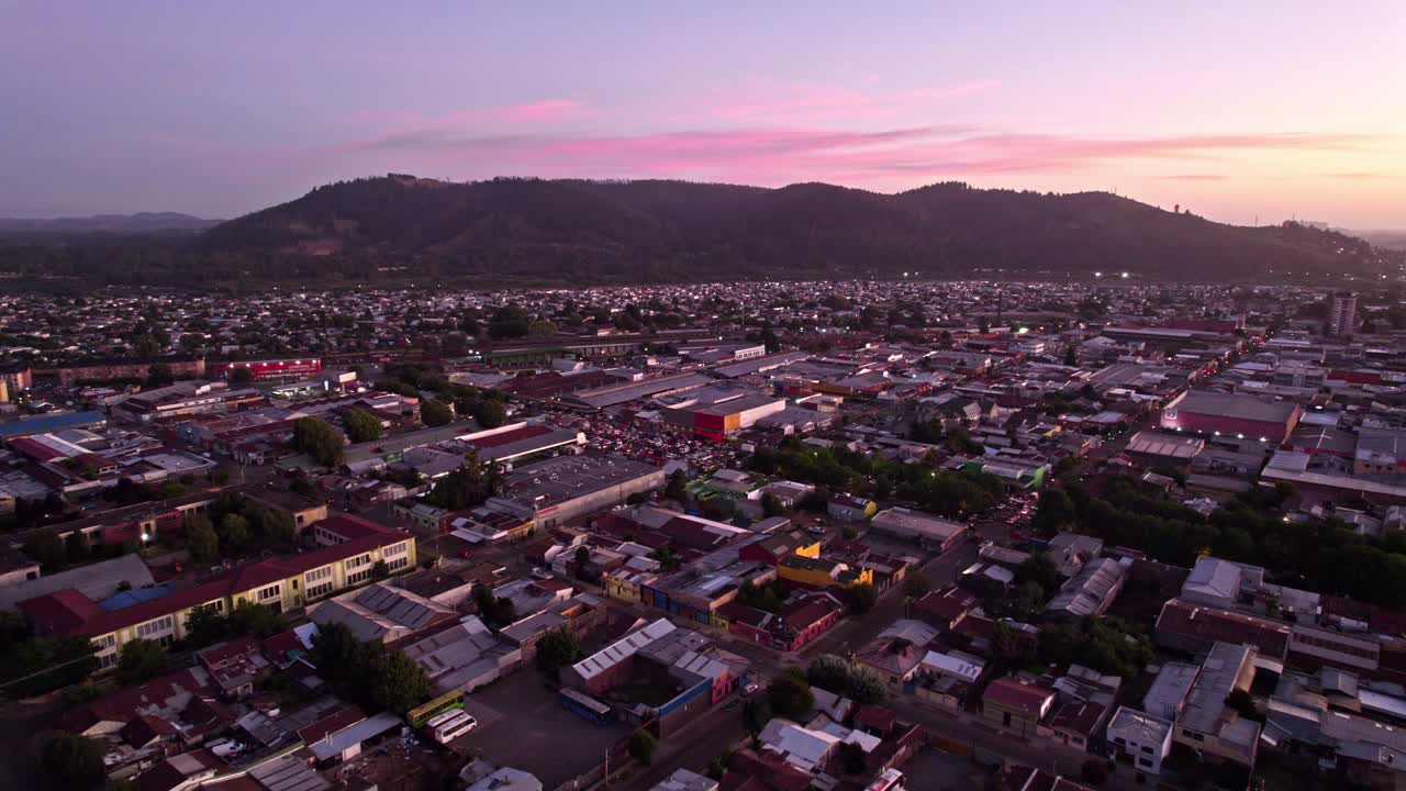 drone aéreo sobre temuco, chile, hora del amanecer, colinas, casas y calles de la ciudad, horizonte rosa, provincia de cautin