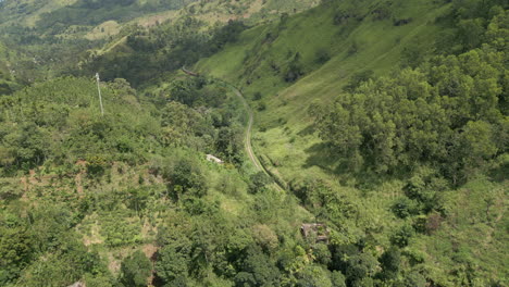 Establishing-Aerial-Drone-Shot-Looking-Down-Vally-in-Demodara-with-Diesel-Train-Coming-Towards-in-Sri-Lanka