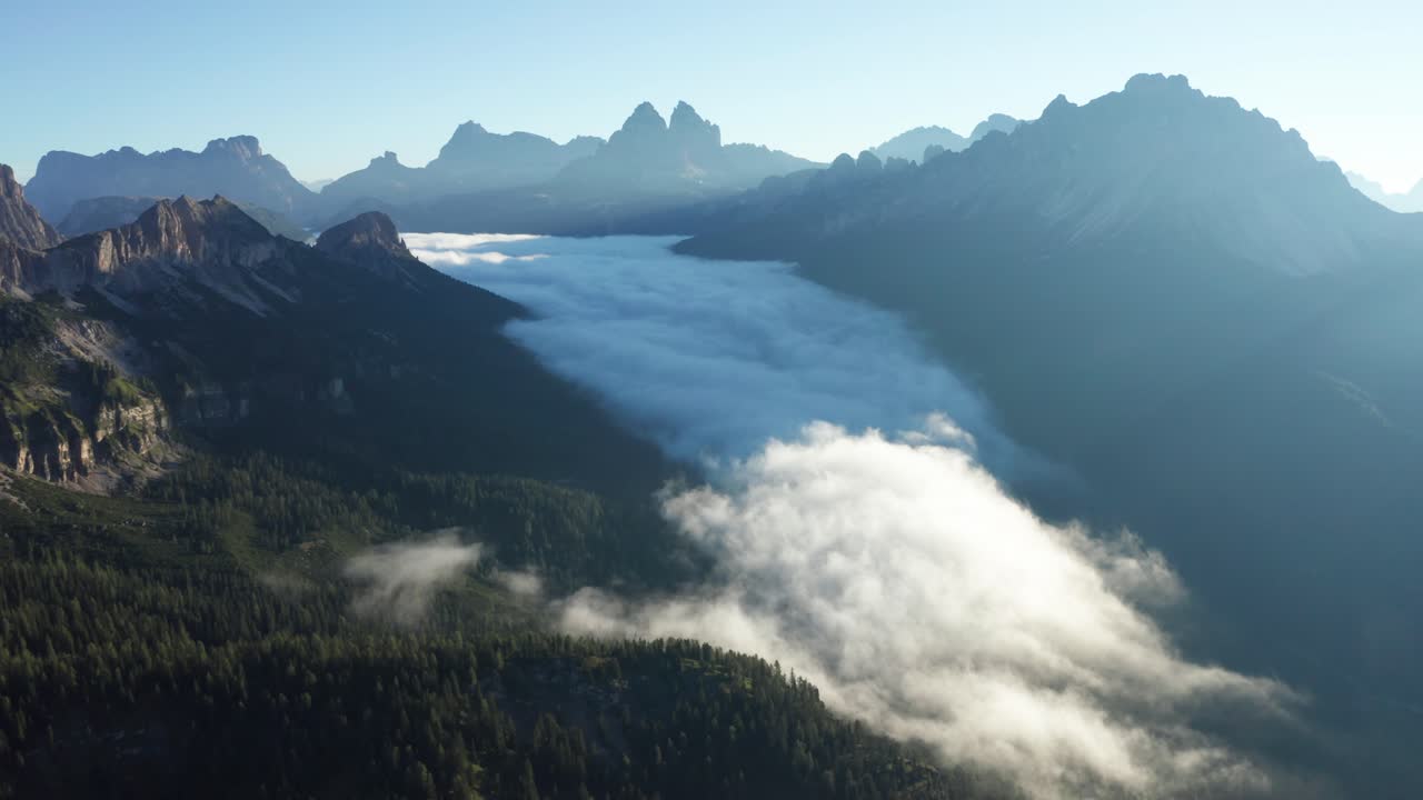 Fjellsdal med lave morgenskyer i Dolomittene