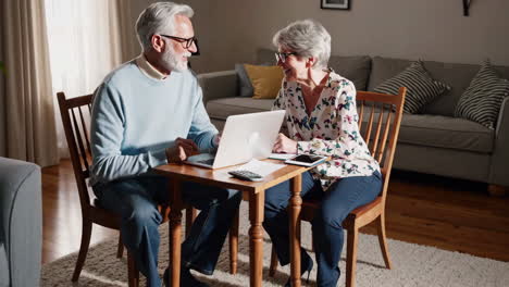 elderly couple engaged with laptop and tablet for home finances
