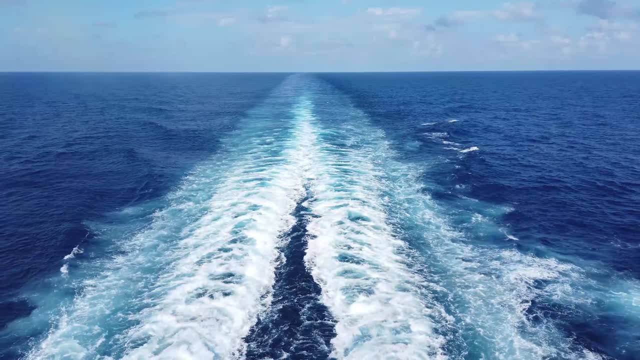 A breathtaking view of a sailboat gliding through deep blue ocean waves, with the endless horizon stretching ahead. The rhythmic motion of the water