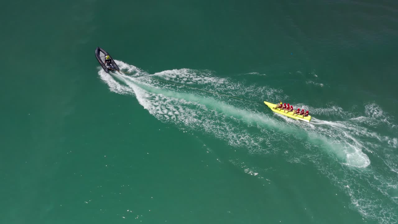 People enjoying banana boat ride towed by a jet ski