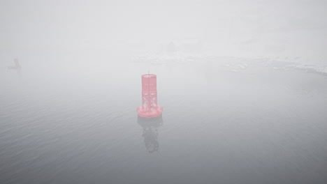 red metal buoy floating on cold norwegian sea