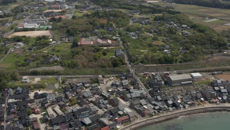 aerial flying over rural japanese town on sea of japan, mikuriya, tottori