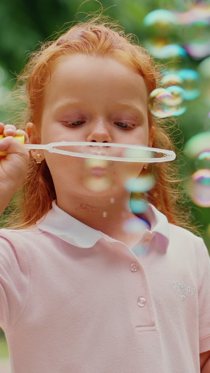 Bambina che gioca con le bolle di sapone in un parco