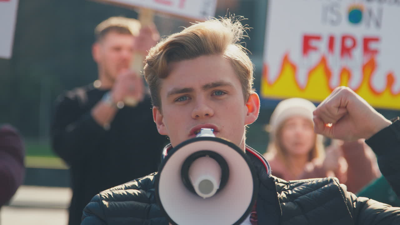 chiusura di manifestanti con cartelli e megafoni in marcia contro il cambiamento climatico