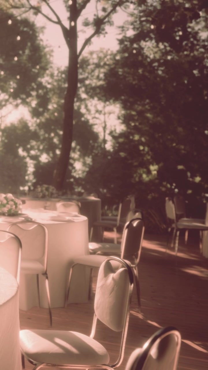 Tables set for dining in a garden during early evening light