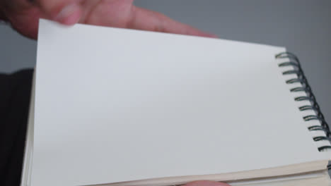 Beautiful-close-up-slow-motion-shot-of-hands-turning-a-page-from-a-notebook-to-write