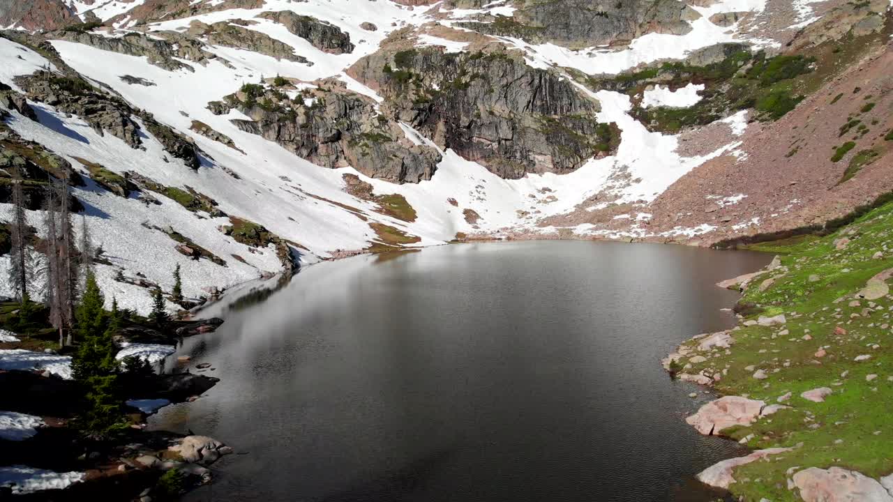 gente junto a un hermoso lago rodeado de altas montañas
