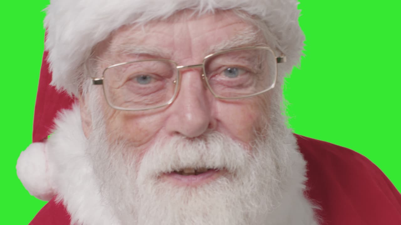 primer plano de santa callando a la cámara frente a la pantalla verde