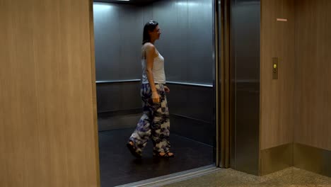 a woman walks into the elevator and the door closes