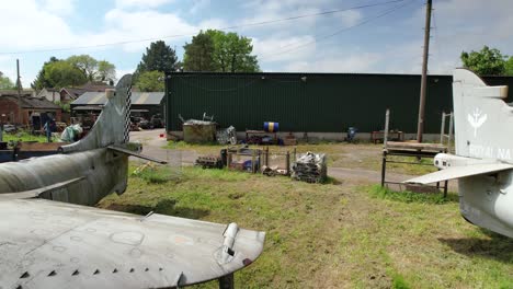 Aerial-view-reveal-between-pair-of-Navy-Sea-Harrier-jets-in-Charlwood-aerospace-logistics-yard