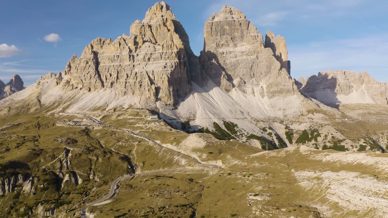 Carrellata aerea indietro che rivela le Tre Cime di Lavaredo nelle Dolomiti italiane.