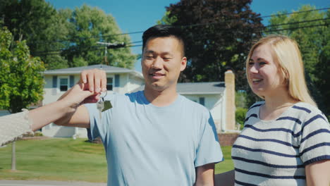 the family gets the keys to their new home young multi-ethnic couple bought a house