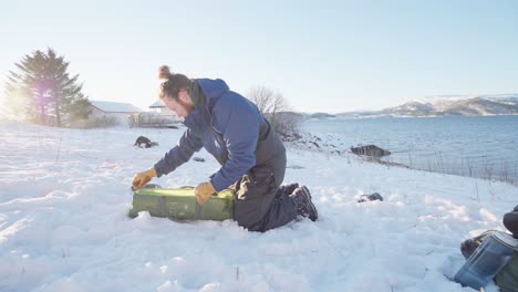 man taking out the tent from the bag during winter in indre fosen, norway