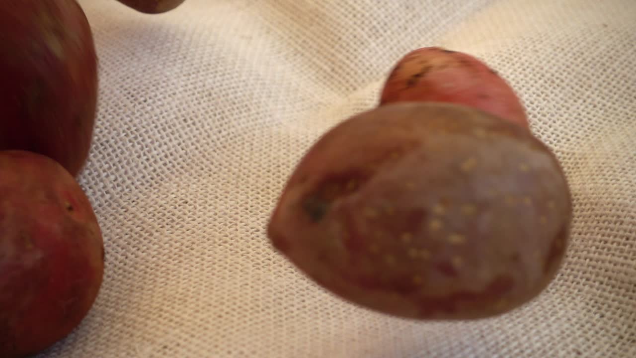 Patate rosse fresche che cadono e rotolano su tessuto di iuta