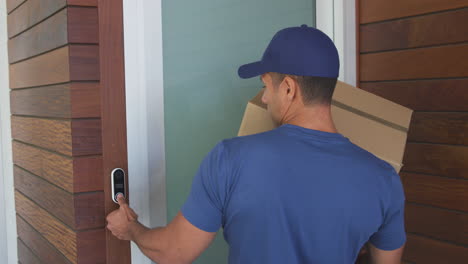 Male-Courier-Leaving-Package-Outside-House-Front-Door-Observing-Social-Distancing-In-Lockdown