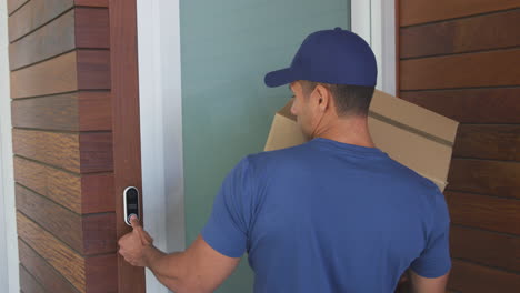mensajero masculino dejando el paquete fuera de la puerta principal de la casa observando el distanciamiento social en el bloqueo