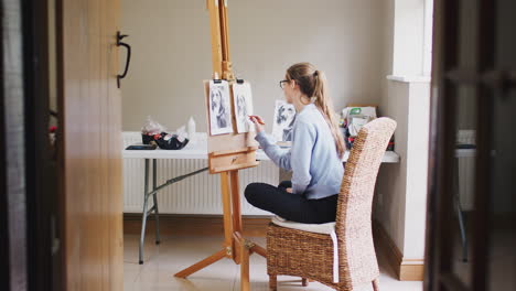 view through door of female teenage artist at easel drawing picture of dog in charcoal