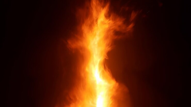 Imponente colonna di fiamma verticale che divampa su sfondo nero, intenso inferno arancione con fumo vorticoso