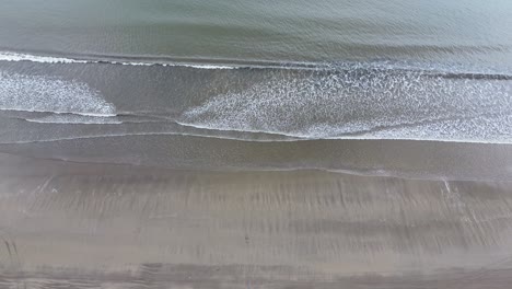 the ocean and the sea come together with soft and gentle waves and beautiful yellow sand