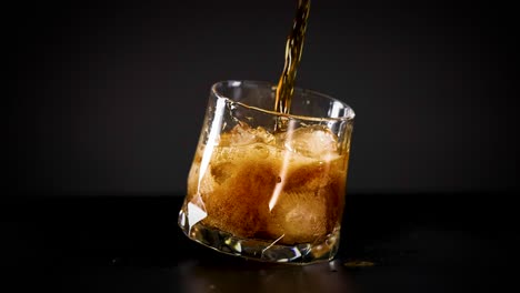 cola being poured into a glass with ice