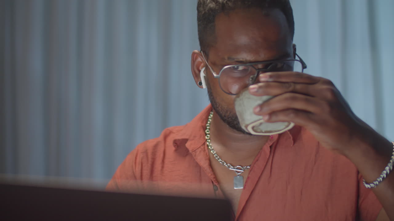 Man Working on Laptop at Home in Evening