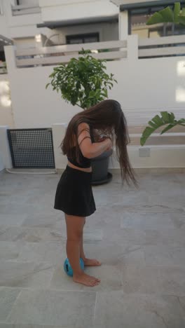 mujer jugando con una pelota azul en un patio
