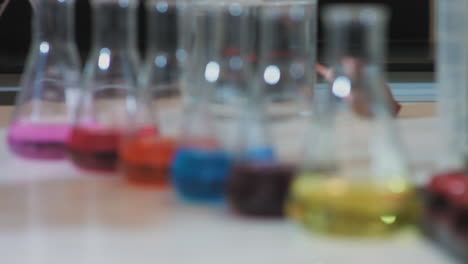 chemical engineering - colorful laboratory chemicals in chemistry lab. rack focus, lab flasks with colorful chemical liquids. laboratory glassware with color liquid. 4k footage