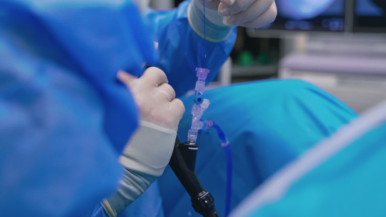 Modern medical equipment in surgeon's hands. Specialist with the help of a nurse perform a complex surgery. Close-up.