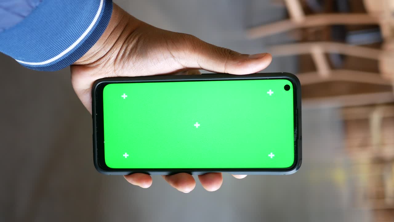 teléfono inteligente en la mano con pantalla verde