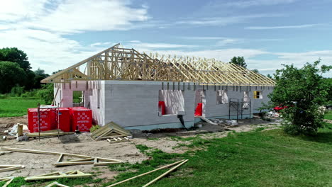 view of a house under construction with the wooden trusses ready to create the roof