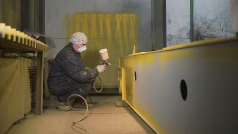 trabajador industrial pintando viga metálica