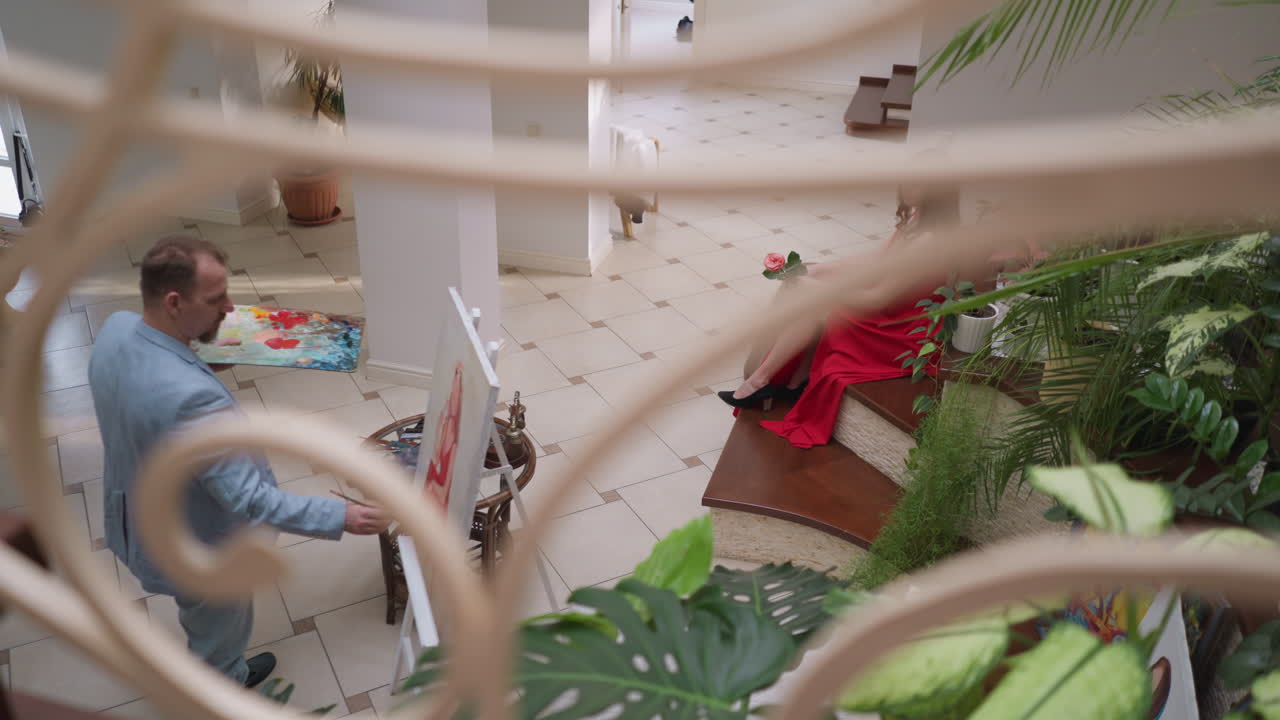 artista y mujer hermosa en el estudio. pintor profesional dibuja el retrato de la esposa amada en el dibujo de modelo en vivo en la sala. belleza posa para el diseñador