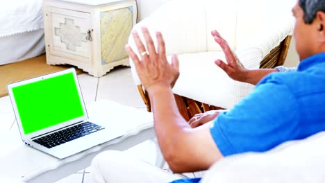 pareja mayor usando computadora portátil en la sala de estar 4k