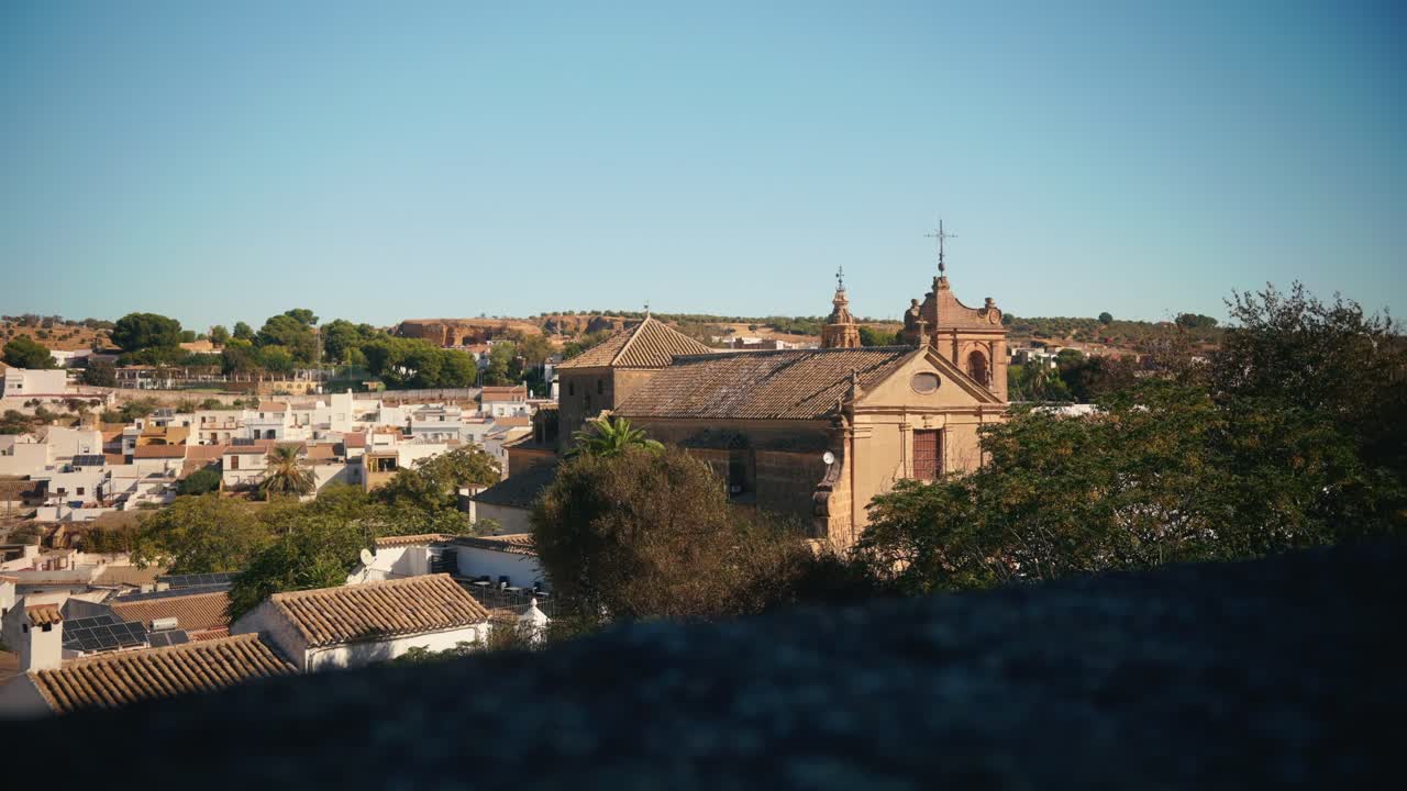 Vista su una città storica con chiesa e colline lontane