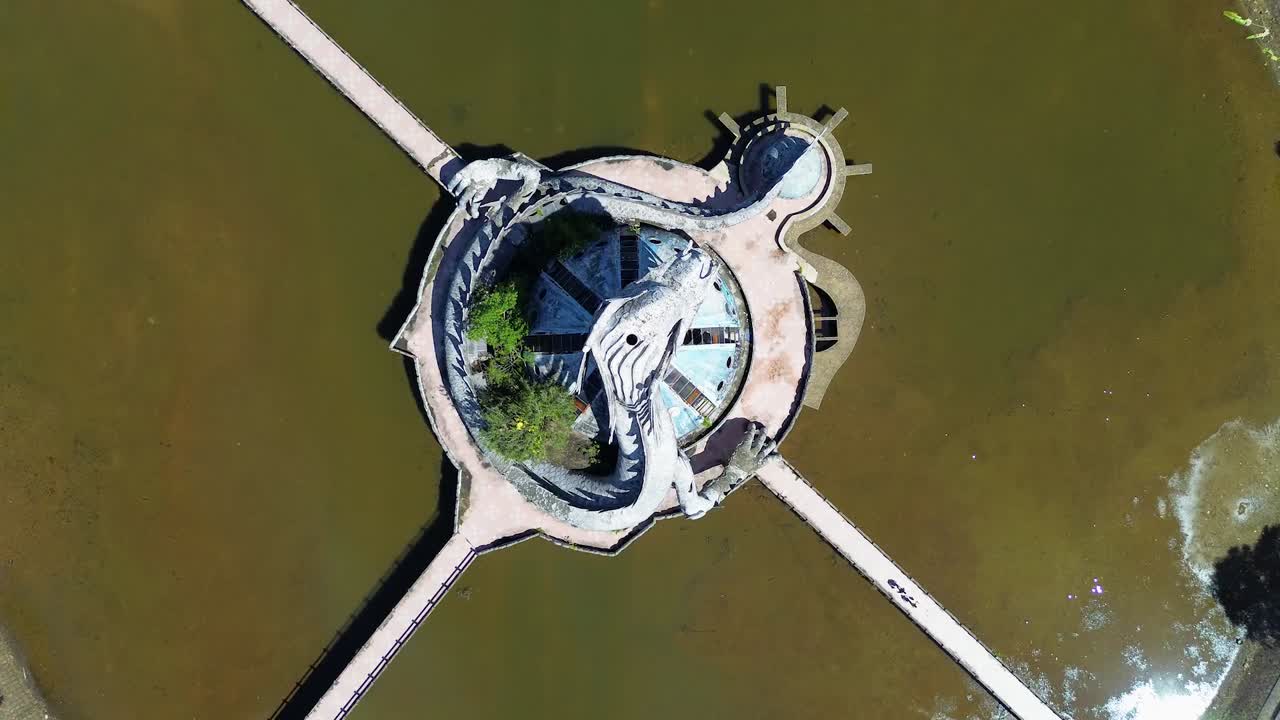 Aerial birds' eye top-down ascending view of Ho Thuy Tien abandoned water park with a huge dragon structure and empty lake in Hue, Vietnam