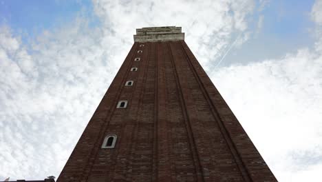 st mark's basilica bell tower against sky with beautiful clouds in venice, italy