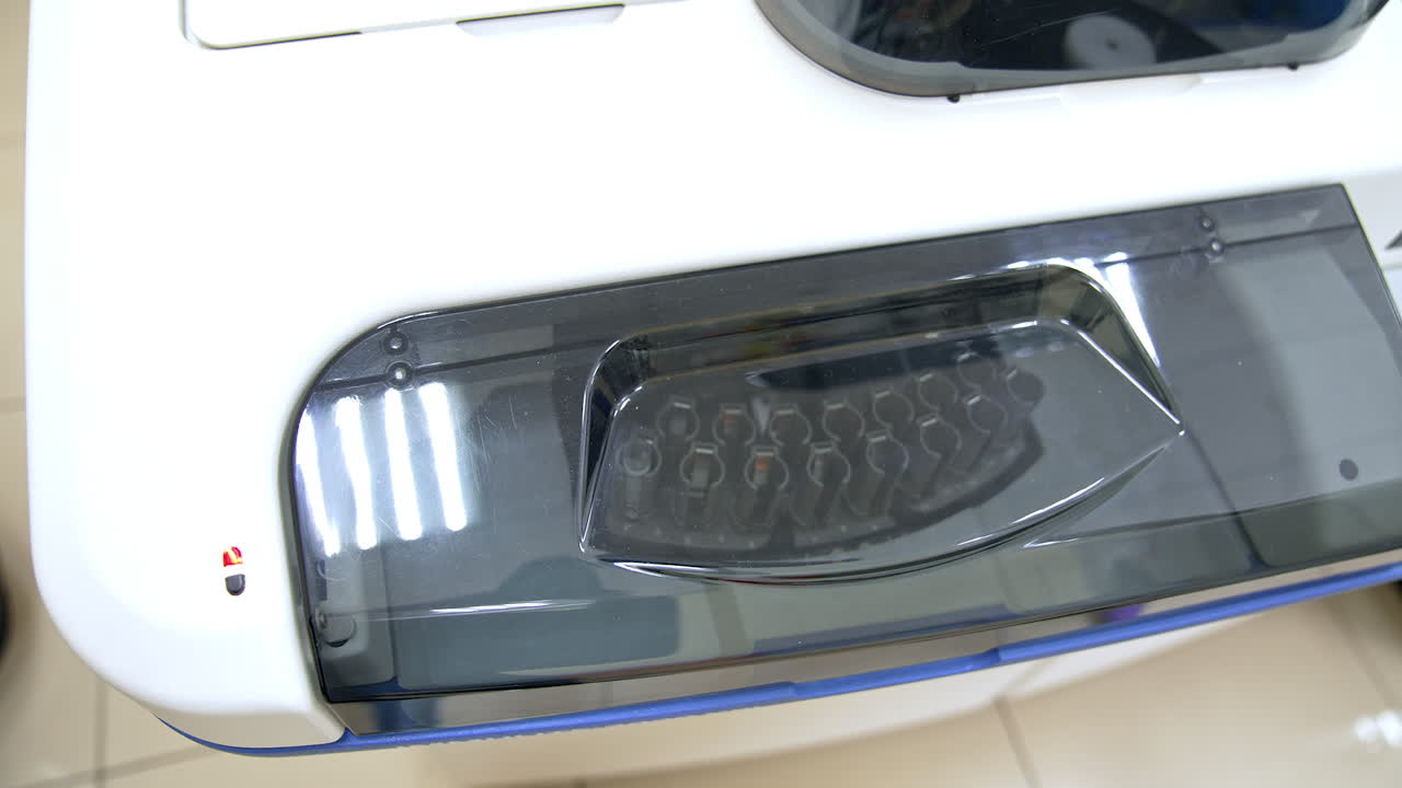 Transparent lid at the apparatus for blood testing. A set of test tubes moving inside the equipment. Innovative science laboratory technics.