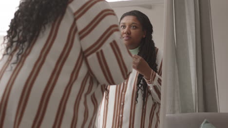 african woman looking at herself in mirror