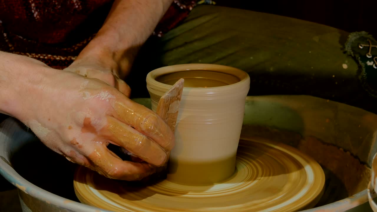 taza de conformación de alfarero profesional con herramienta especial en taller de cerámica