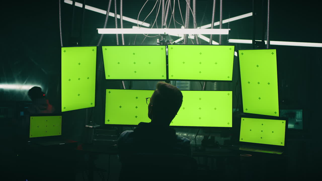 Hacker in front of multiple monitors