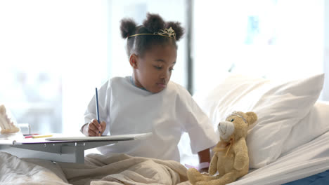 african american girl holding mascot in hospital bed, slow motion