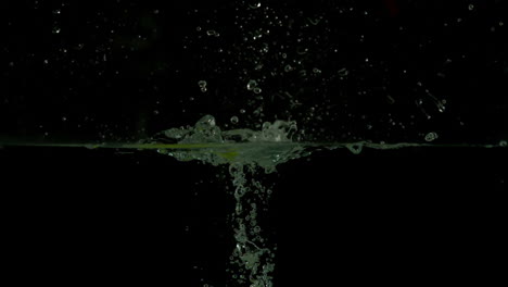 Green-apple-plunging-into-water-on-black-background