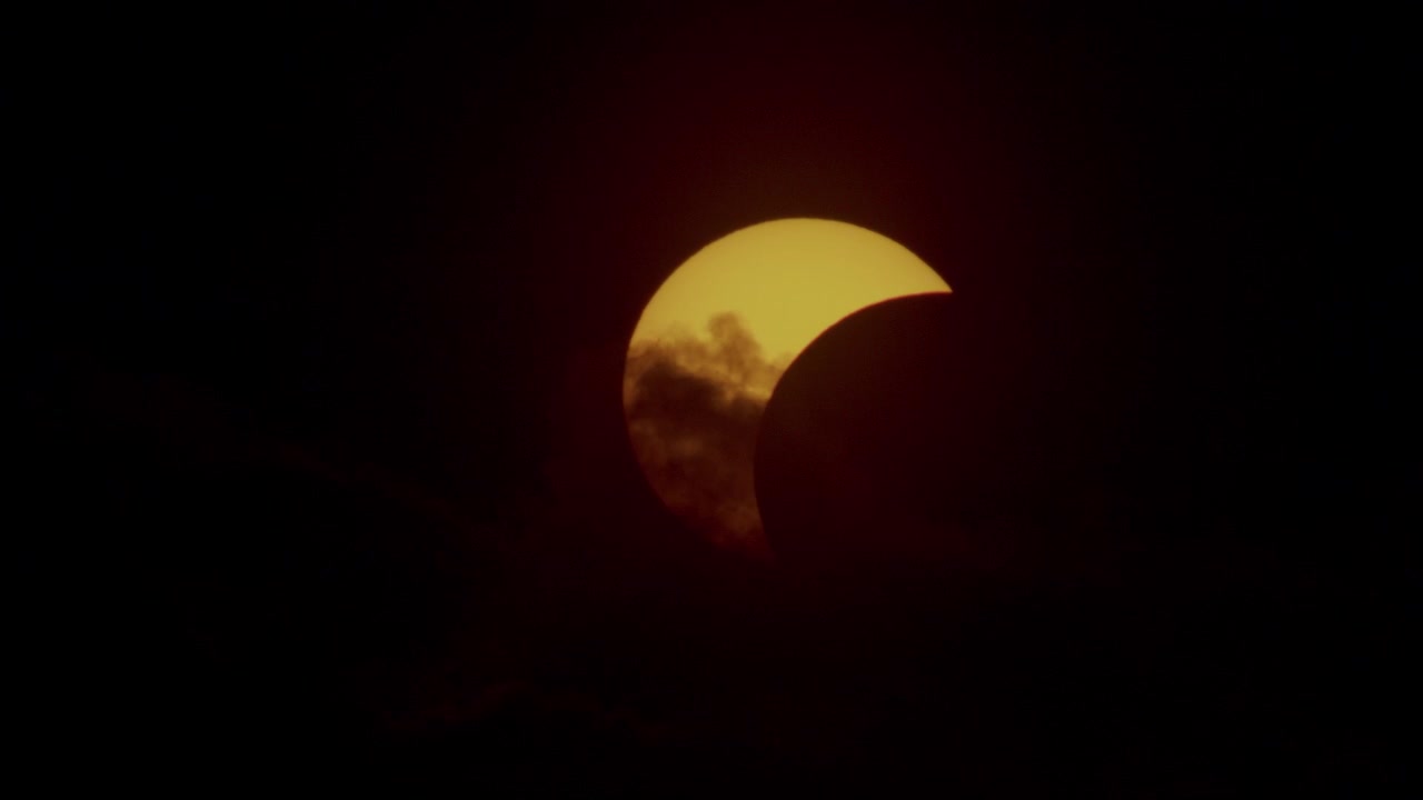 Partial solar eclipse near horizon at sunset time