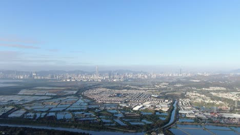 Línea-Fronteriza-De-Hong-Kong-Y-Shenzhen-Sobre-Casas-Rurales-De-Hong-Kong-Con-El-Horizonte-De-Shenhzen-En-El-Horizonte,-Vista-Aérea