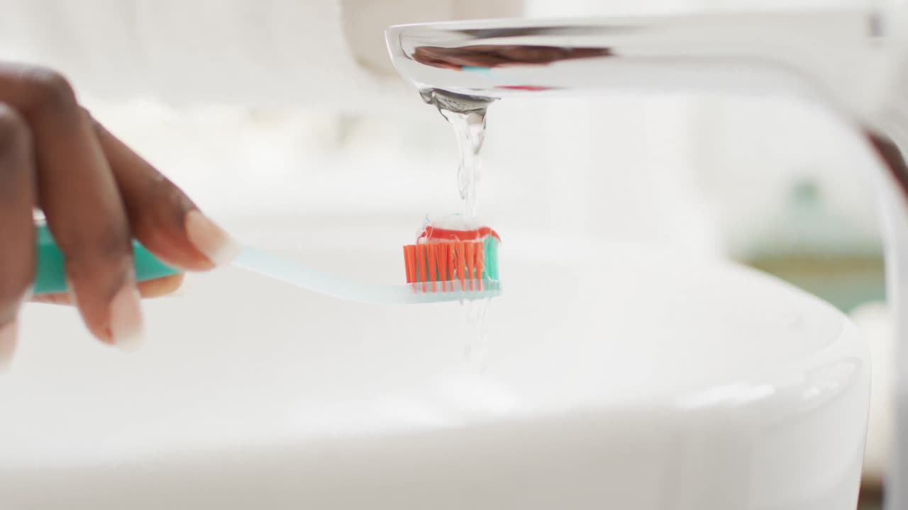 video de las manos de una mujer afroamericana sosteniendo un cepillo de dientes