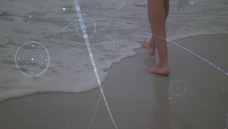 network of connections against low section of a woman walking at the beach