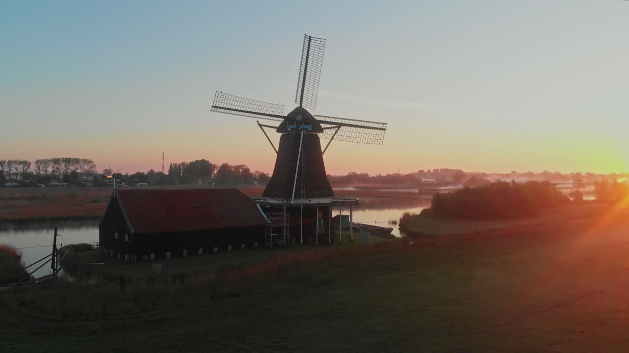 Vista aerea del tradizionale mulino a vento Het Prinsenhof che emerge da un prato nebbioso all'alba a Zaandam, Paesi Bassi.